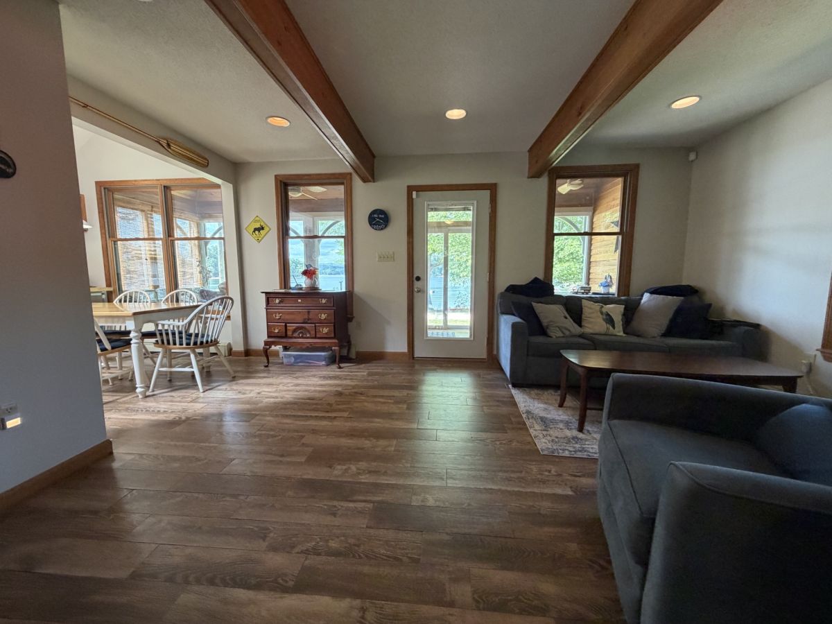 Stretch out in this open, airy living space where rich wood beams draw your eye up and natural light pours in from every direction. Sink into the plush sofas, gather around the dining table, and feel instantly at home.