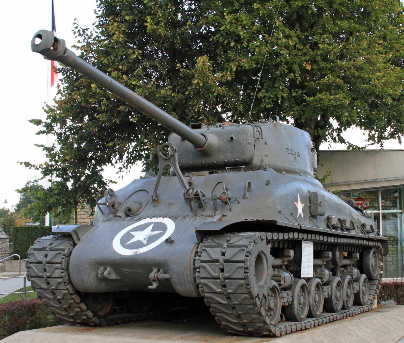 World War II era tank on display outdoors, gray with a white star emblem on the front.